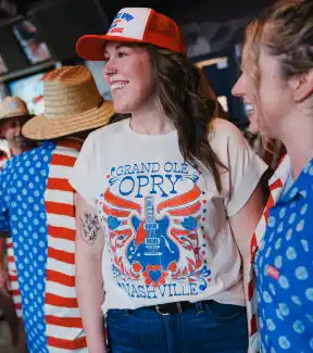 A cream-colored short-sleeved t-shirt with a colorful graphic of a guitar and wings.