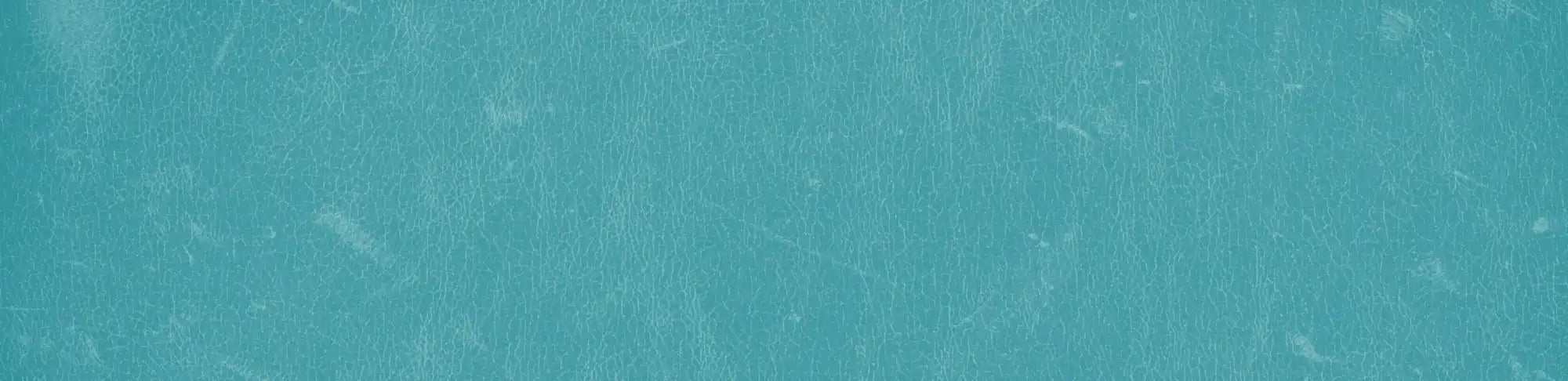 A weathered teal wall with subtle variations in texture.