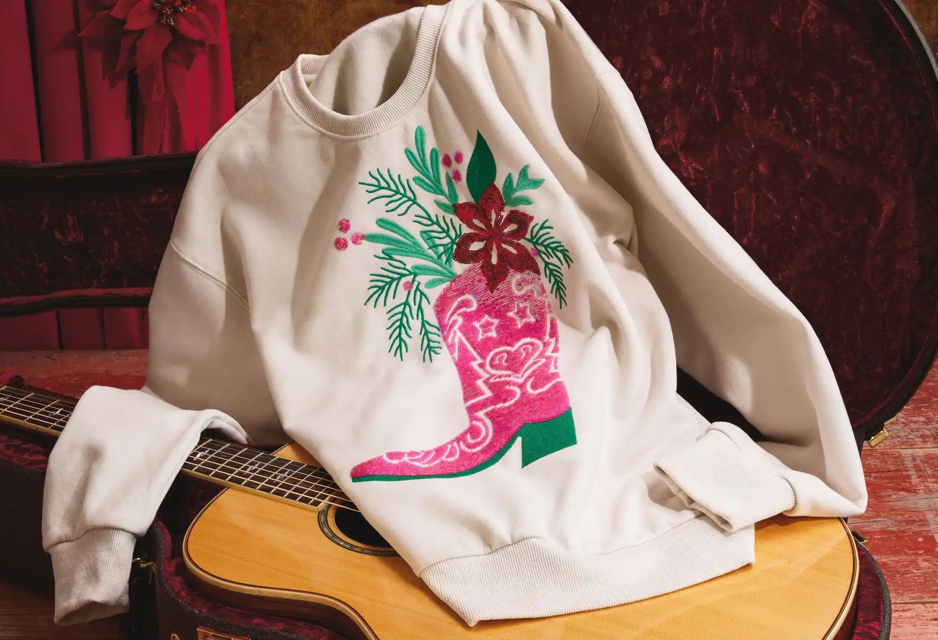 White long-sleeved sweatshirt with a pink cowboy boot and Christmas floral design.