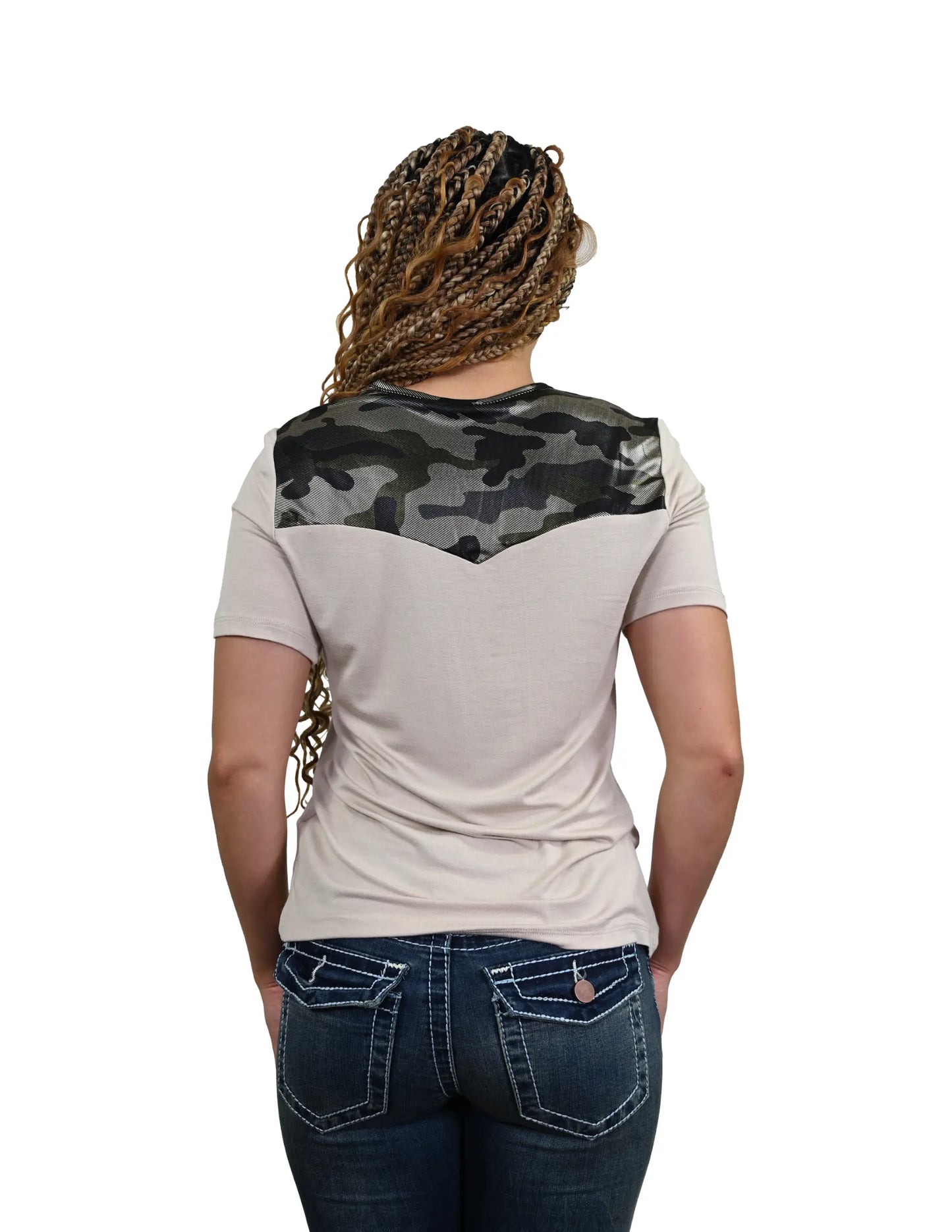 Woman wearing a beige t-shirt with a camouflage pattern on the back, standing against a white background.