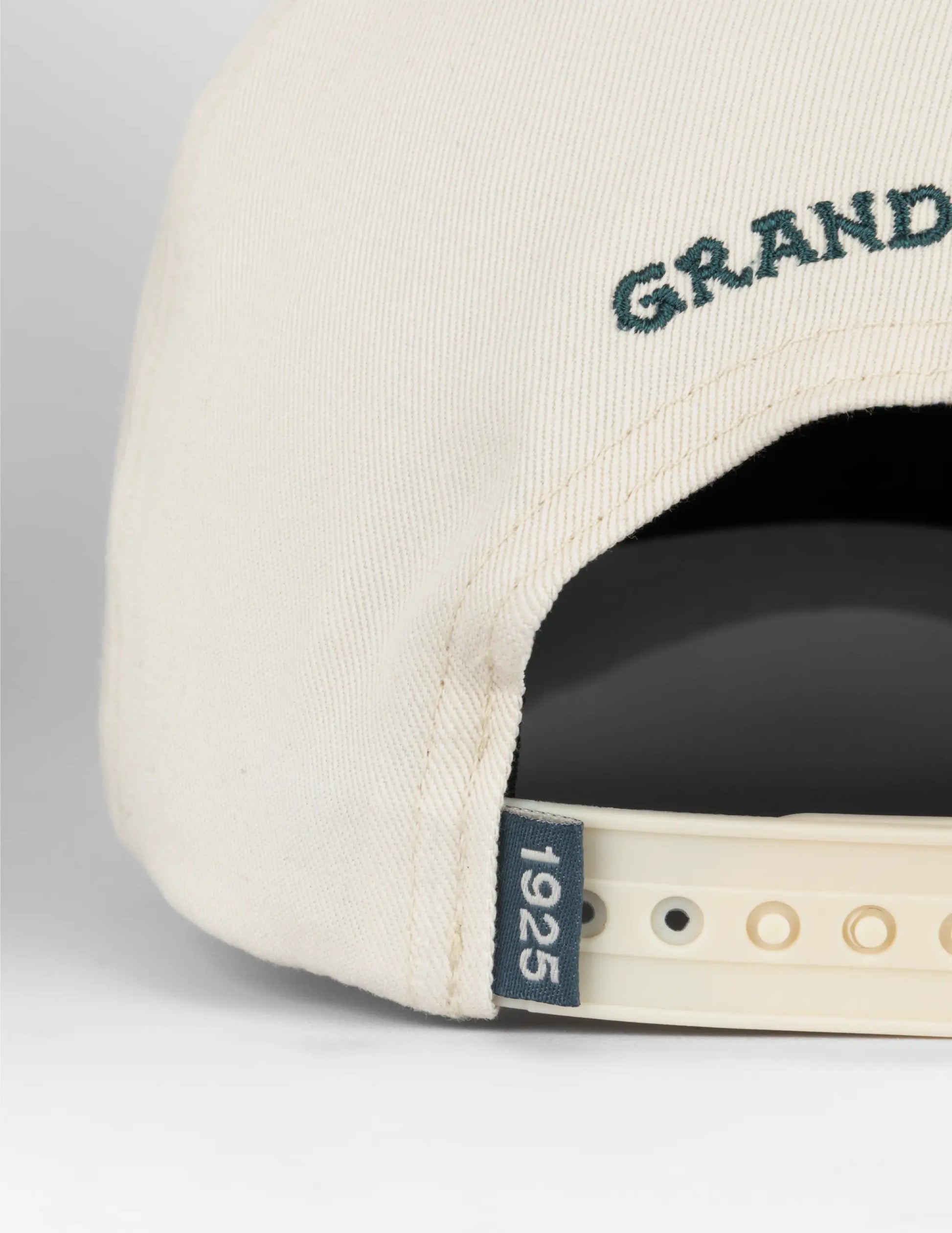 Cream-colored baseball cap with dark green grand embroidery and navy blue 1925 tag opry long live country hat