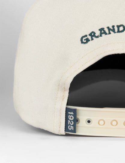 Cream-colored baseball cap with dark green grand embroidery and navy blue 1925 tag opry long live country hat