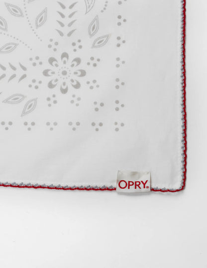 White embroidered handkerchief with gray floral patterns and red stitched edge in the opry paisley traveler bandana cream