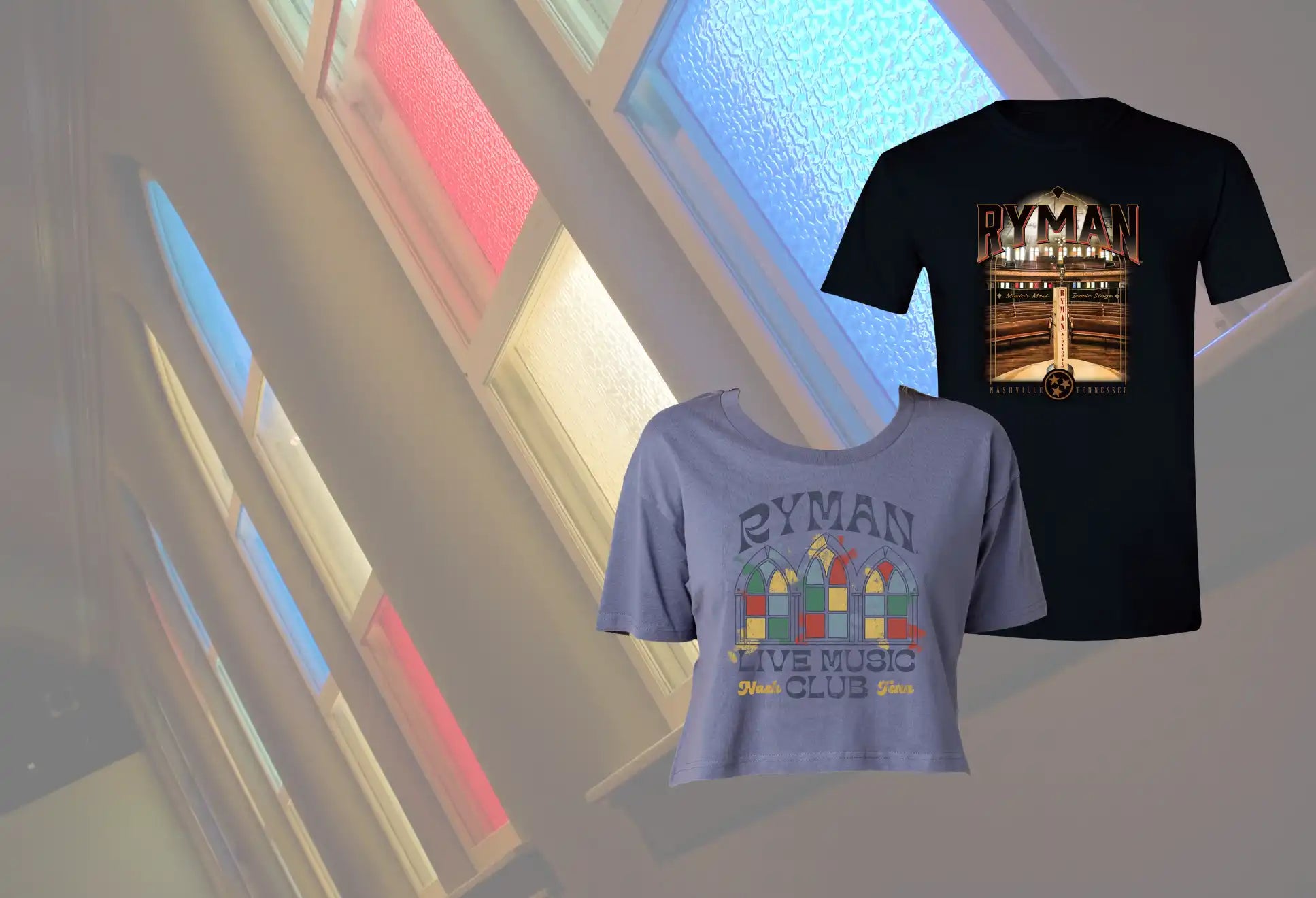 Two Ryman-branded t-shirts: a black men’s shirt with a graphic of the auditorium and a light blue women’s cropped shirt with a stylized stained-glass window design.
